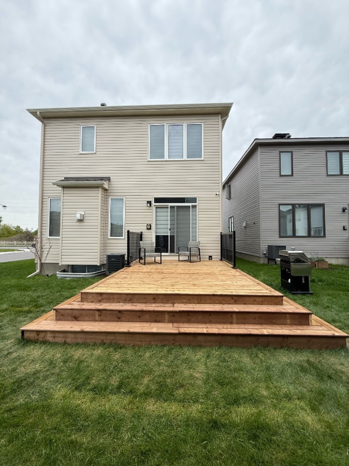 Custom wood deck with wrap-around steps in Ottawa - Gordon Landscaping